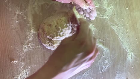 Top-down-shot-of-female-hands-making-dough-for-bread-with-a-plastic-cleaning-card-at-home