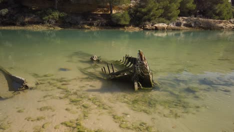 Tilt-Down-Reveal-of-Sunken-Skeleton-Boat-in-Calm-Waters