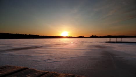 Beautiful-white-winter-lake-at-golden-sunrise,-beauty-of-tranquil-Finland