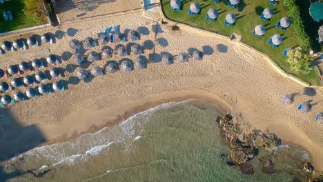 Luftaufstieg-über-Strand-Und-Sonnenschirme-Im-Resort-Auf-Der-Insel-Zakynthos