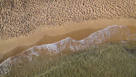 Luftbild-Von-Wellen,-Die-Das-Sandige-Ufer-Des-Strandes-Treffen