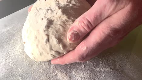 Putting-wheat-bread-dough-on-baking-paper-and-preparing-it-to-go-to-the-oven