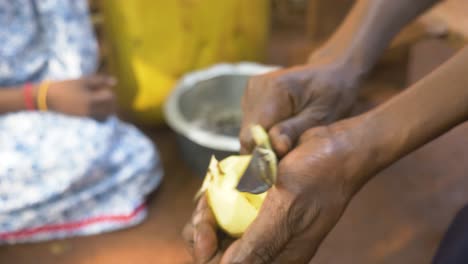 Nahaufnahme-Der-Hand-Einer-Afrikanischen-Frau,-Die-Kartoffeln-Mit-Einem-Messer-Schält