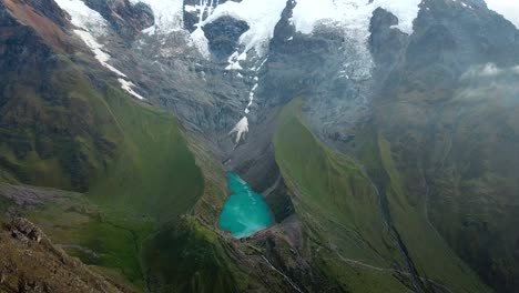 Aerial,-tracking,-drone-shot-panning-towards-lake-Humantay,-Andes-mountains,-overcast-day,-in-Peru,-South-America