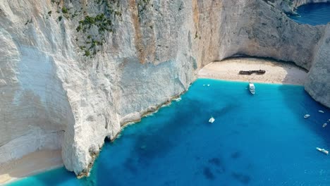 AERIAL:-Shipwreck-beach-with-huge-cliffs-and-blue-water