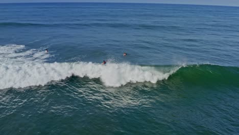 Aerial:-surfer-riding-and-crashing-on-big-wave-off-Pacific-Coast