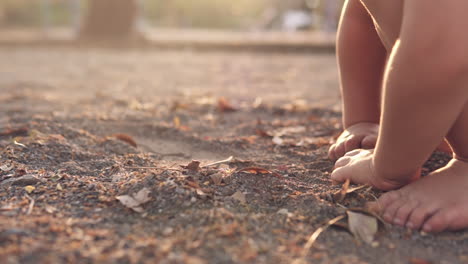 Slow-Motion-close-up-video-of-little-kids-hands-grabbing-and-playing-with-dirt-in-the-sand-box-of-a-park