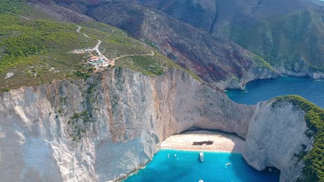 Wide-aerial-view-of-spectacular-Navagio-beach-surrounded-by-limestone-cliffs-and-turquoise-color-water