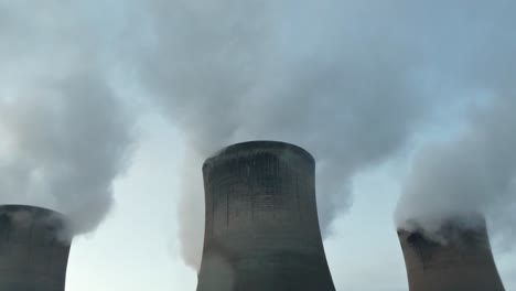 Power-plant-cooling-towers-fossil-fuel-smoke-air-pollution-from-below-chimney-stacks