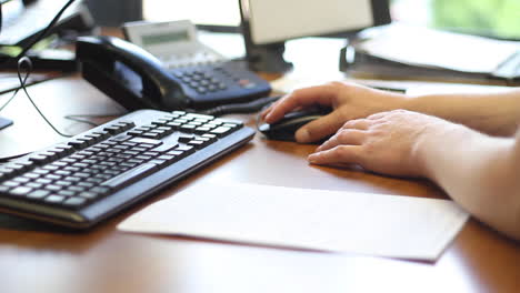 Weibliche-Hand-Mit-Computermaus-Und-Eingabe-Auf-Der-Tastatur-Im-Unternehmensbüro