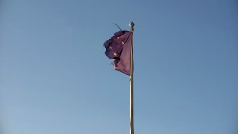 Torn-damaged-flag-of-European-Union-in-stormy-weather,-Collapse-of-EU-abstract-concept