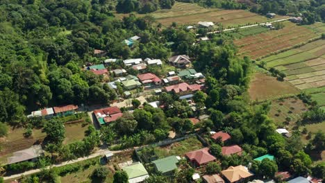 Enfoque-Aéreo-Rápido-De-Un-Pequeño-Pueblo-Moderno-Junto-A-Un-Bosque-Y-Tierras-Agrícolas-En-Filipinas-En-4k