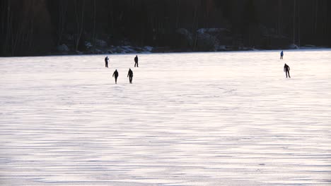 Silhouette-Group-Of-Ice-Skaters-Enjoying-the-Winter-Lake