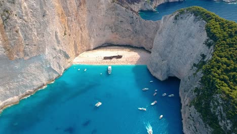 Aerial-panorama-of-anchored-yachts-by-Navagio-Beach,-Zakynthos,-Greece
