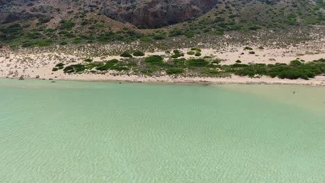 Der-Berghang-In-Balos-Beach-Auf-Der-Insel-Kreta-Griechenland,-Wo-Die-Salzwasserlagune-Auf-Das-Land-Trifft,-Luftdrohnenüberführungsaufnahme