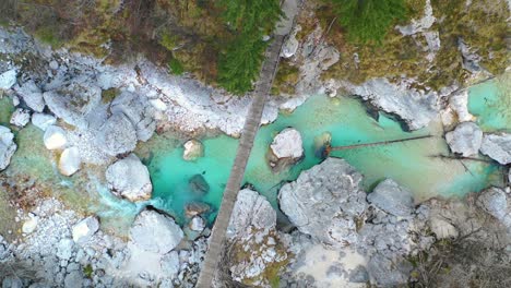 Soca-river-with-a-wooden-footbridge,-aerial-view-from-drone,-top-down