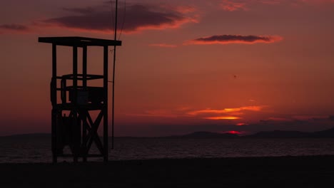 Wunderschöner-4K-Sonnenuntergang-Im-Zeitraffer-An-Einem-Strand-Mit-Einem-Rettungsschwimmerturm-Im-Vordergrund-Und-Dem-Sonnenuntergang-Im-Hintergrund-Im-Mittelmeer---Mallorca,-Spanien