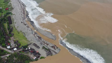 Aerial:-Murky-river-water-on-Mexican-Pacific-coast,-freshwater-meets-sea