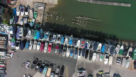 Small-boats-in-dry-dock-storage-at-Hebe-Haven-pier,-Hong-Kong,-Aerial-view