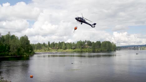 Slow-motion-of-the-fire-brigade-rescue-helicopter-carries-water-in-the-tank-in-Norway-forest
