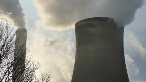 Power-plant-cooling-towers-fossil-fuel-smoke-air-pollution-backlit-by-sunrise
