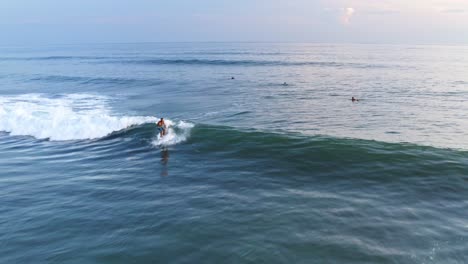 Aerial:-surfer-catching-perfect-breaking-wave-and-riding-wave-to-shore