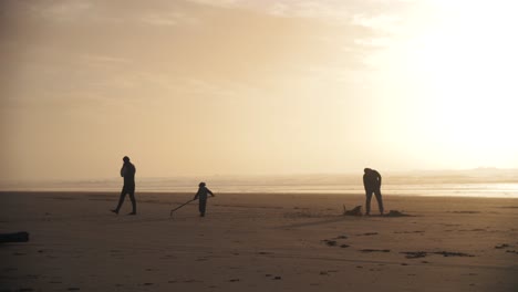 4k-slow-motion-footage-of-a-family-playing-on-the-beach-with-their-child-while-sunset---enjoying-holiday-weekend-together