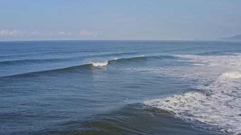 Amazing-wave-breaking-off-empty-surfing-beach,-ocean-sea-aerial-view