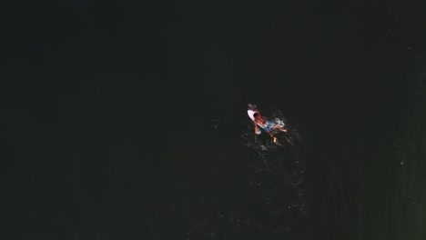 Aerial:-surfer-paddling-to-surf-breaking-wave-then-pulling-out,-bird's-eye-view