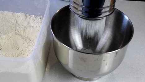 Sifting-Flour-in-to-a-Stainless-Steel-Mixing-Bowl