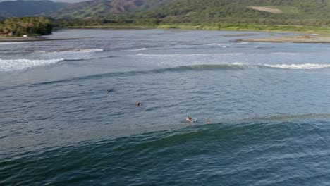 Surfer,-Die-Bei-Sonnenuntergang-Wellen-Vor-Der-Pazifischen-Küste-Fangen,-Luftbild