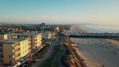 Gente-Caminando-Al-Aire-Libre-En-Pacific-Beach-En-California-San-Diego-Mientras-Se-Pone-El-Sol---Imágenes-Aéreas-De-4k---Muelle-De-Cristal