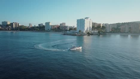 Drone-footage-in-4k-of-boat-cruising-in-calm-water-in-Mallorca---Palmanova-beach---Magaluf-at-Sunset---Mediterranean-Sea