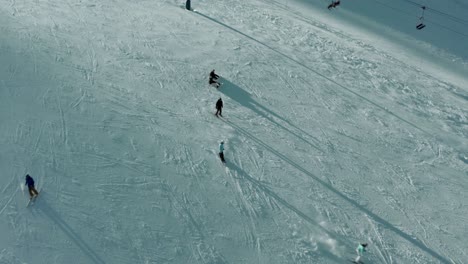 Skiers-and-snowboarders-on-beautiful-winter-ski-slope,-aerial-view
