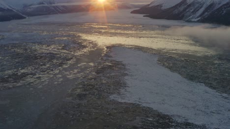 Eisbedecktes-Meerwasser-In-Der-Bucht-Während-Des-Sonnenaufgangs-über-Den-Bergen,-Antenne