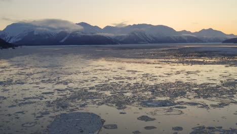 Flat-icy-waters-of-Cook-Inlet-in-Alaska-during-early-morning-sunrise,-aerial
