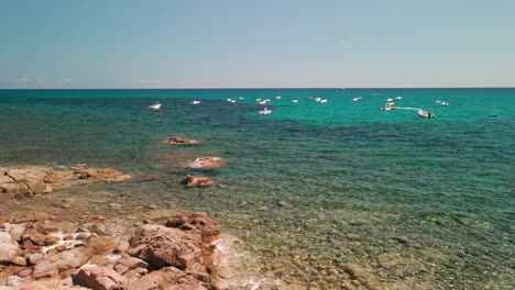 Boote-Auf-Ruhigem-Meer-Mit-Felsiger-Küste-Und-Transparentem-Wasser-An-Sonnigen-Tagen-In-Sardinien,-Italien