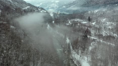 Antenne:-Nebelhafte-Flussszene-Im-Winter-In-Einem-Schneebedeckten-Berghangtal,-Französische-Alpen