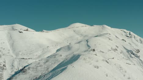 Ski-Lift-Ascending-up-Snow-Covered-Mountaintops-Slopes