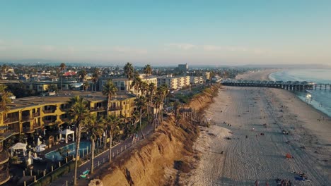 Amazing-view-of-the-Pacific-Beach-promenade-while-sunset-in-San-Diego---people-walking-outdoors---enjoying-sunset---4k-drone-shot