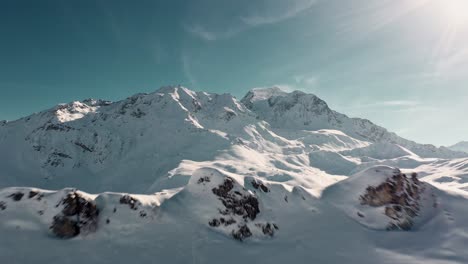 Aerial:-beautiful-Les-Arcs-ski-resort-landscape,-reveal-behind-snowy-mountaintop