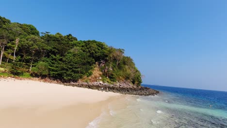 La-Hermosa-Playa-De-Arena-Blanca-En-Ko-Phi-Phi,-Tailandia,-Compuesta-Por-Un-Océano-Azul-Tranquilo-Y-árboles-Gloriosos,-Perfecta-Para-Las-Vacaciones-De-Verano,-Plano-General