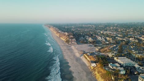 Stunning-wide-aerial-view-of-the-California-coastline-at-moonlight-beach-at-a-warm,-clear-and-sunny-day-with-calm-blue-ocean-near-San-Diego---4k-footage