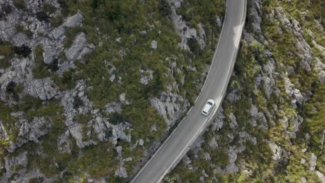 Aerial-view-in-4k-of-a-car-driving-on-a-moutain-road---curvy-road-in-the-mountains---Mallorca-Serra-de-Tramuntana