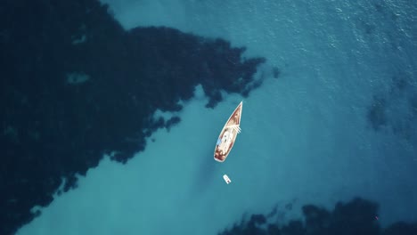 Breathtaking-top-down-view-in-4k-of-a-sailing-boat-in-crystal-clear-turquoise-water-in-the-mediterranean-sea