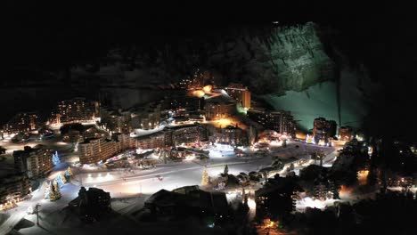 Christmas-winter-ski-resort-at-night,-ski-run-and-hotel-lights,-aerial