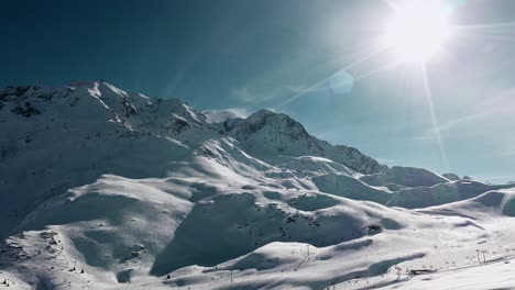 Aerial:-Les-Arcs-ski-resort,-mountain-ski-runs-covered-in-winter-snow