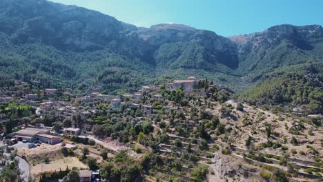 4k-drone-footage-of-Parròquia-Sant-Joan-Baptista-in-Deia,-Mallorca---Stunning-landscape-in-Mallorca-west-coast-with-massive-cliffs-in-backgound---Spanish-village-in-the-mountains---Serra-de-Tramuntana