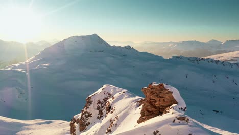 Aerial:-beautiful-sunset-snowy-mountain-peak-in-French-Alps,-winter-off-piste-ski-slope