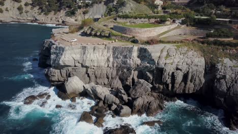 Stunning-4k-drone-footage-of-the-west-coast-of-Mallorca--Serra-de-Tramuntana---People-sitting-on-cliff-in-Cala-Banyalbufar